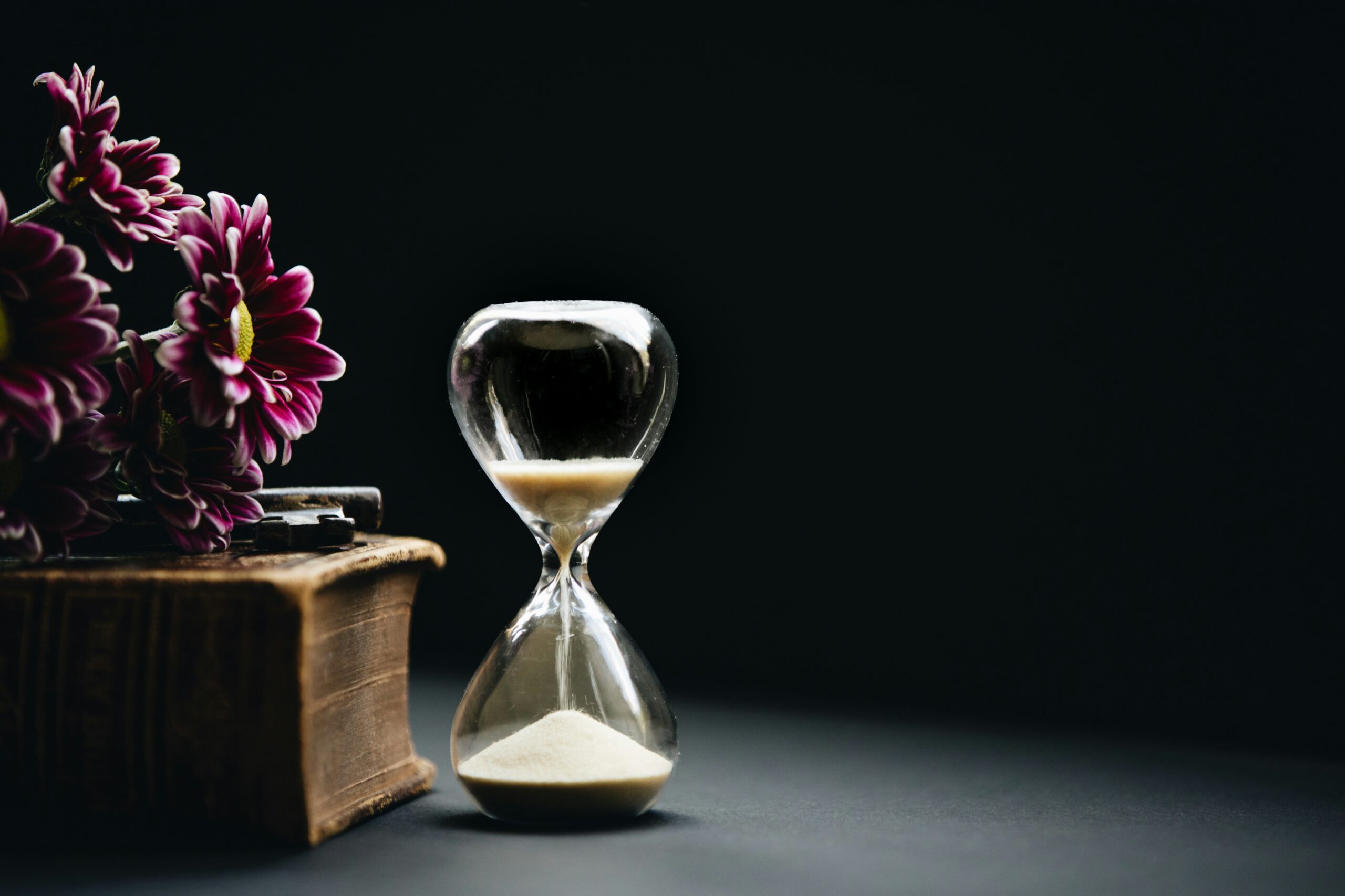 hour glass, flowers on a book